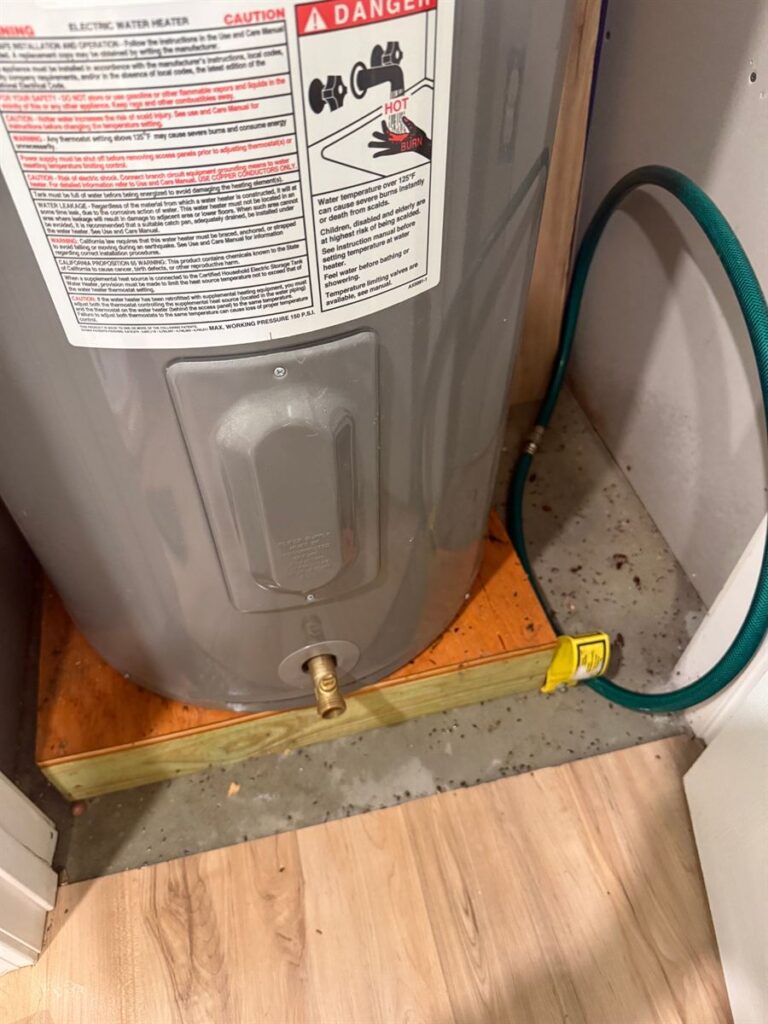 Rodent droppings and debris on the floor around a water heater before cleanup by Northern Pest Solutions in Central Maine